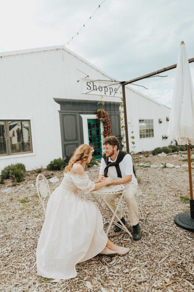 romantic paris café style engagement photo with the couple holding hands across a bistro table