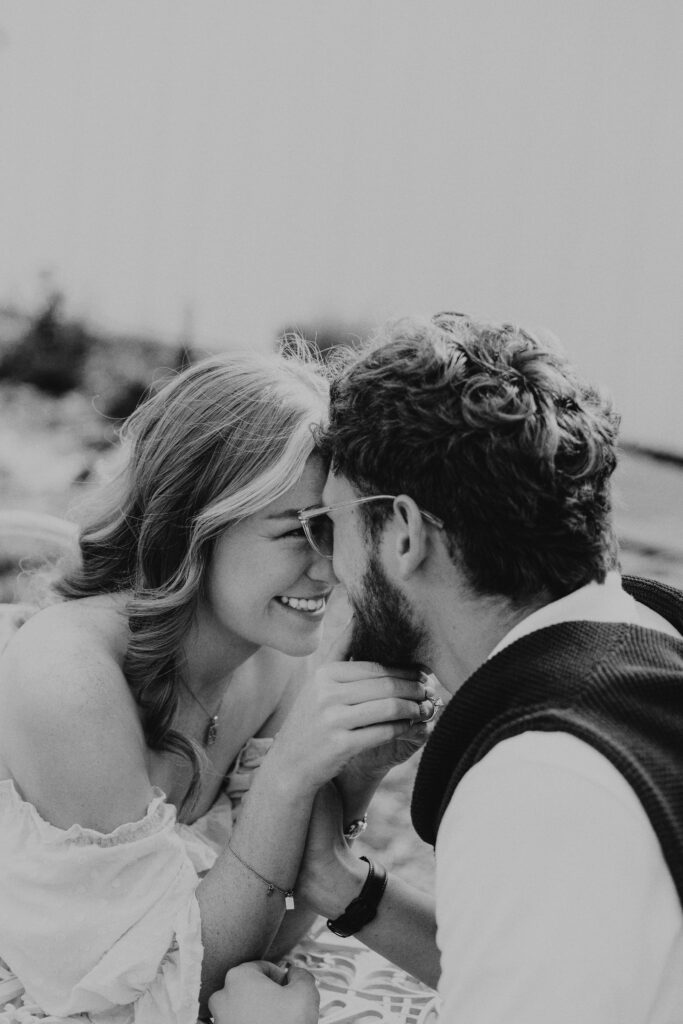 french engagement photo of couple laughing together in a garden café setting