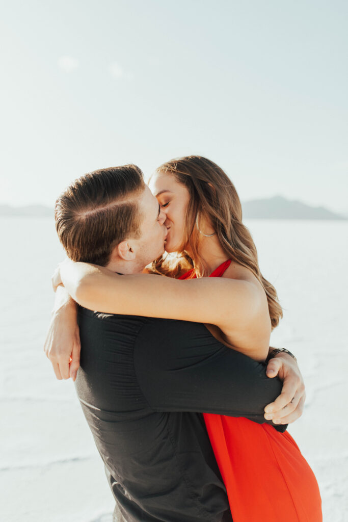 Close-up of romantic kiss between couple against the white Salt Flats landscape.