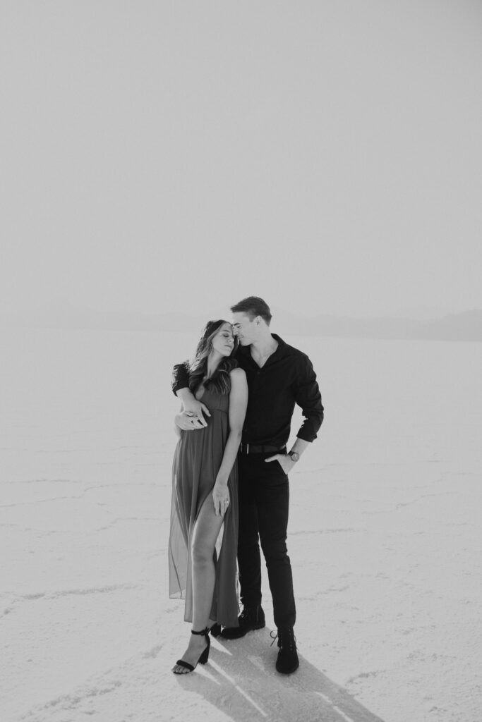 Black and white portrait of couple embracing during their destination Salt Flats engagements, creating a timeless and romantic feel.