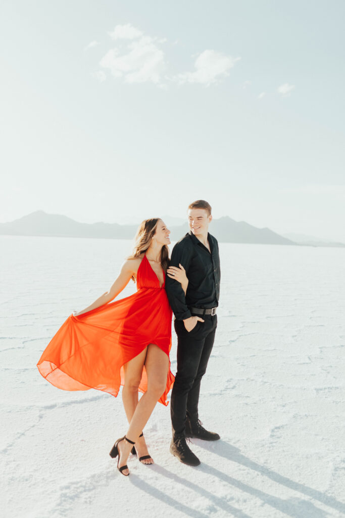Close-up of red gown flowing against the white Salt Flats landscape.