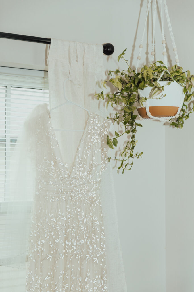 Bride's lace wedding dress hanging in a Crested Butte mountain lodge before the ceremony.